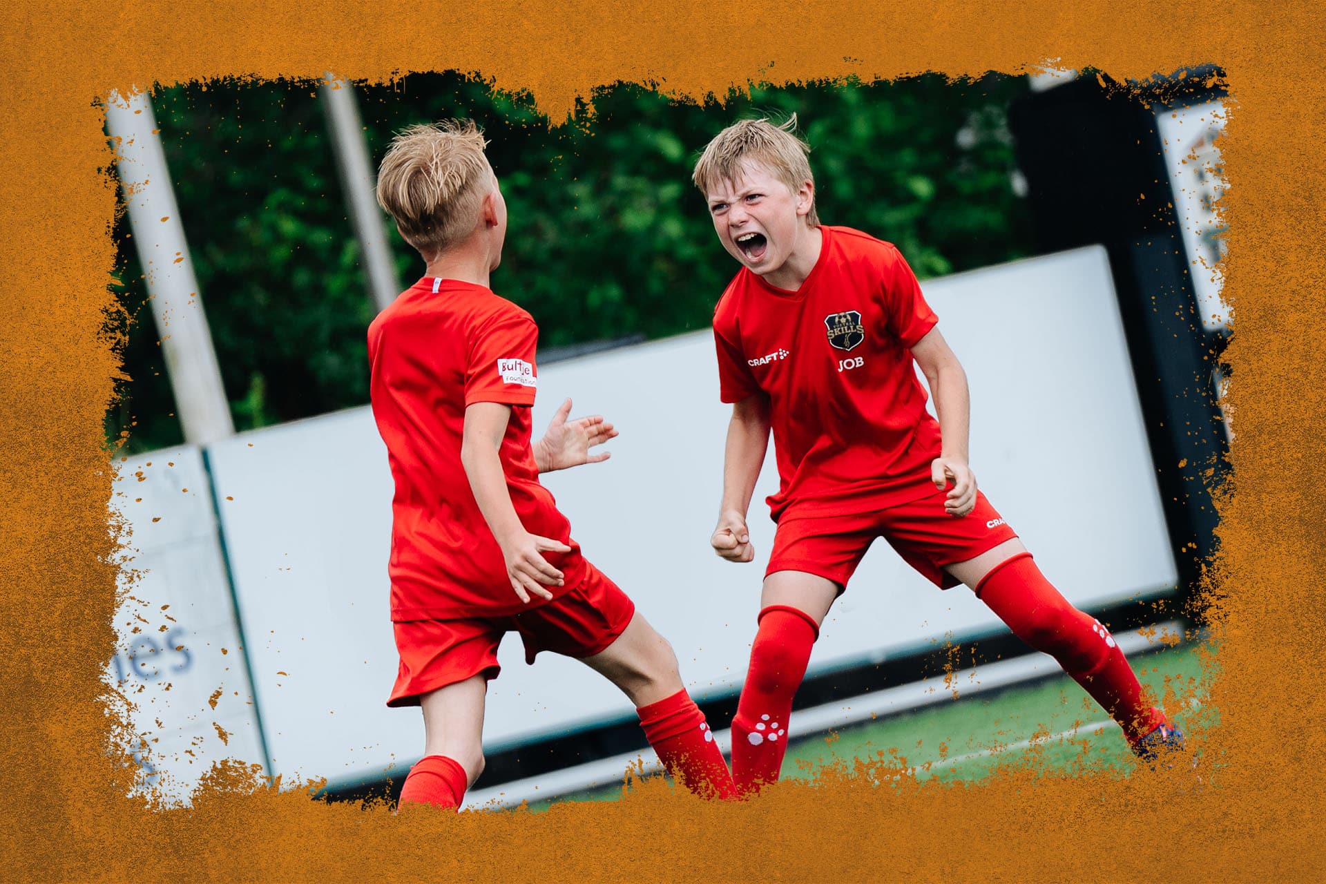 Twee juichende jonge spelers tijdens de Skills Voetbaldagen bij STEVO van FC VoetbalSkills in WK-stijl