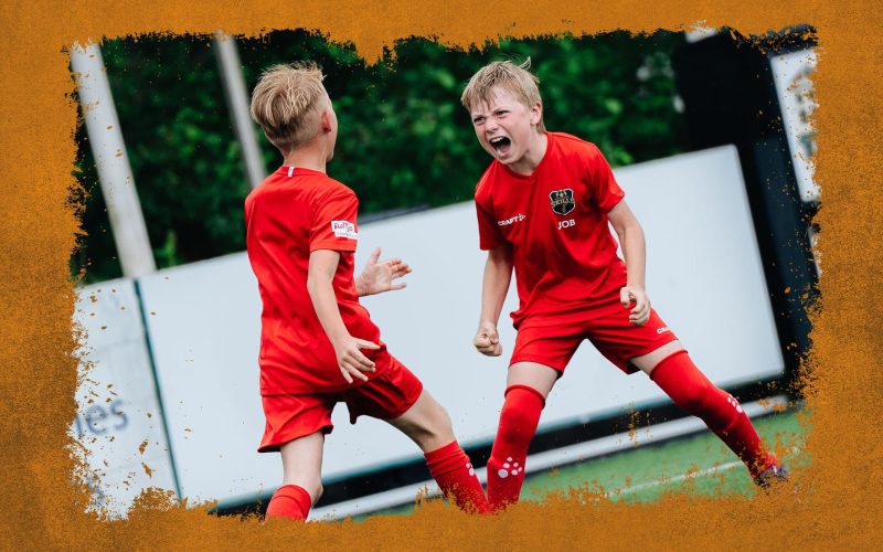 Twee juichende jonge spelers tijdens de Skills Voetbaldagen bij STEVO van FC VoetbalSkills in WK-stijl